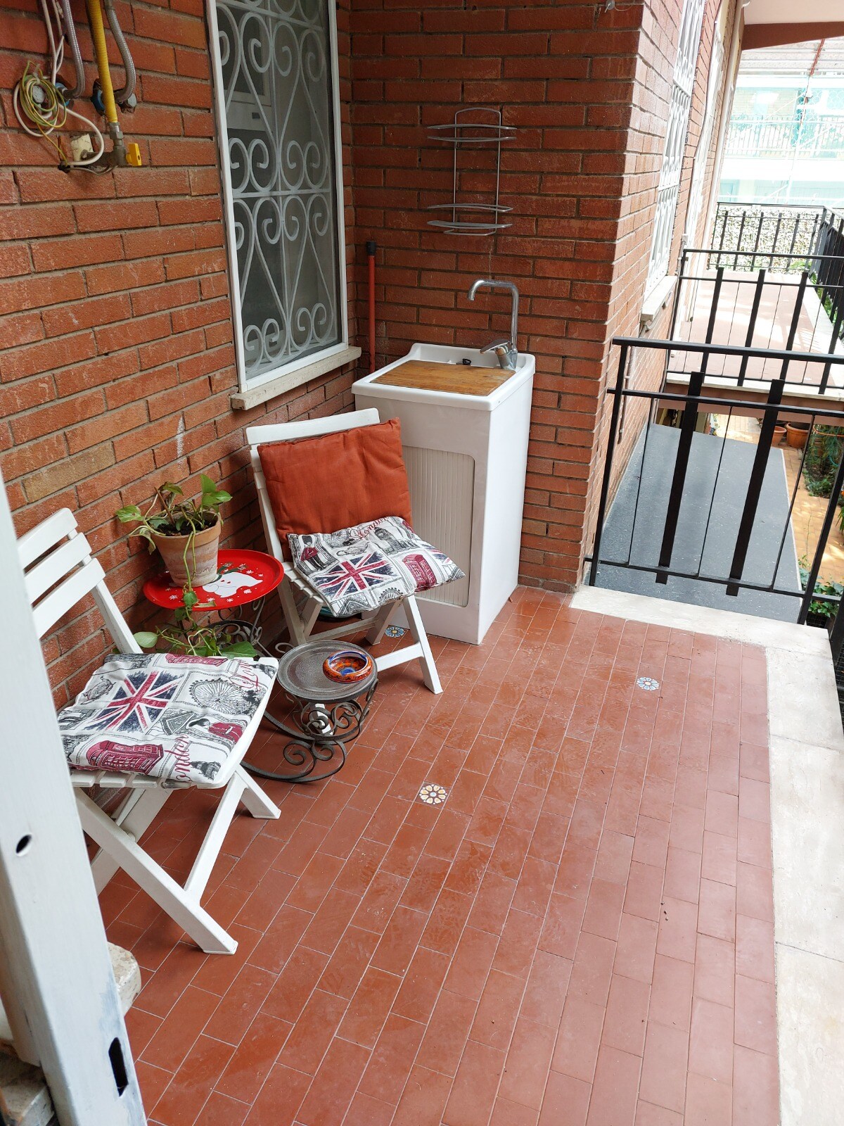 Balcone attrezzato per fumare, con tavolino e sedie